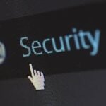 Close-up view of a mouse cursor over digital security text on display.